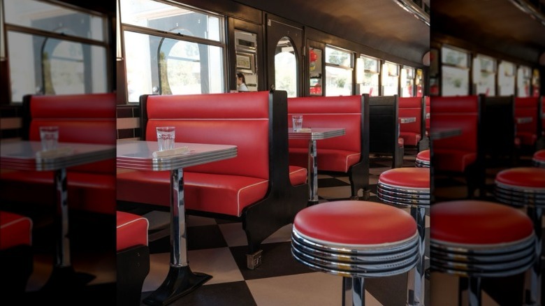 Diner with red leather booths and stools, white-and-chrome tables, and black-and-white tiles