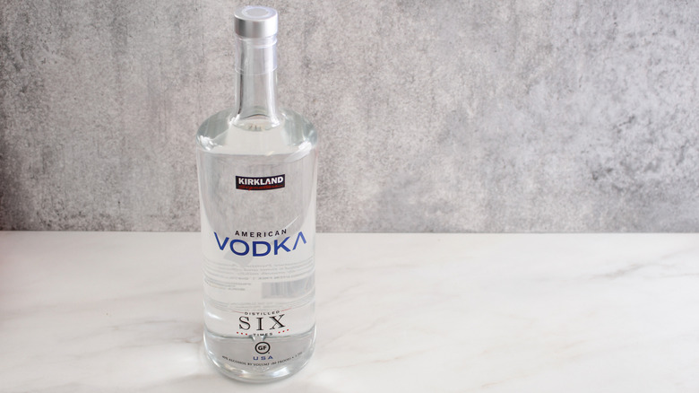 A closeup of a Kirkland American Vodka bottle against a stone background