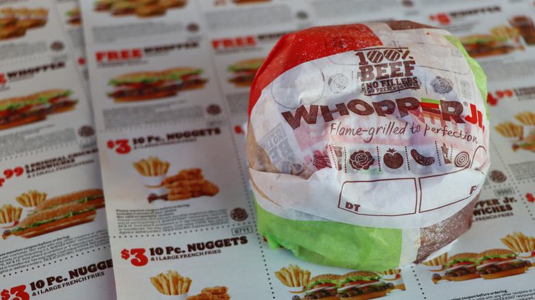 Burger King Whopper Jr. wrapper sitting on Burger King coupons