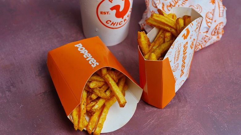 Popeyes fries in different containers and Popeyes drink