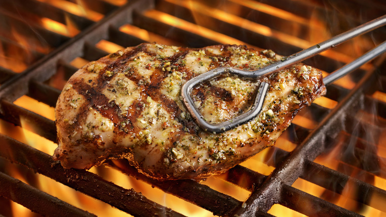 Up-close shot of grilled chicken breast over grill