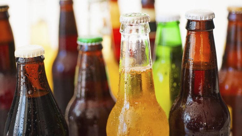 Close-up of the top portions of various bottles of beer