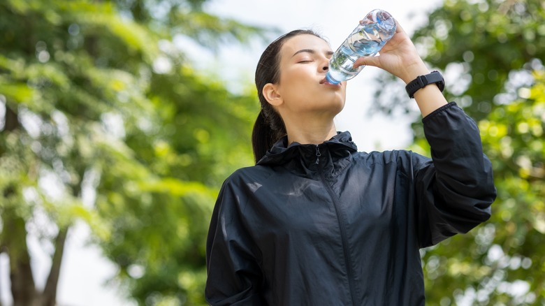 Woman drinking from plastic bottle