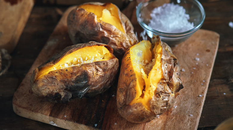 Sliced baked potatoes on a board