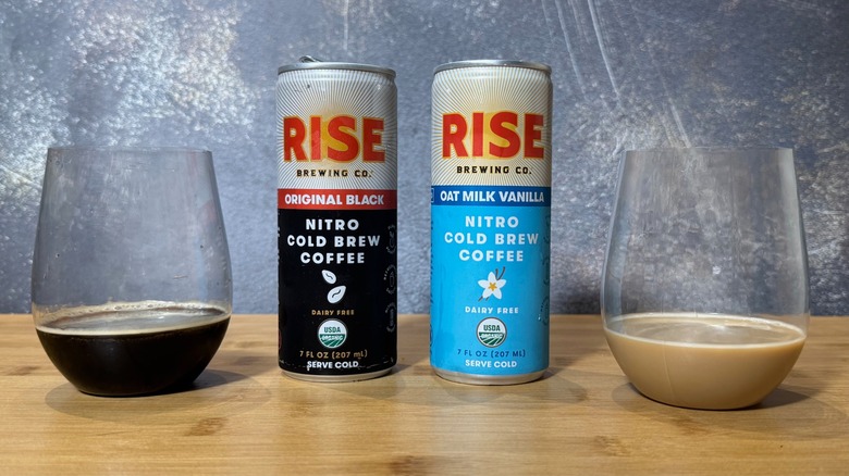 Cans of RISE Brewing Co. Original Black and Oat Milk Vanilla Nitro Cold Brew Coffee on table with glasses