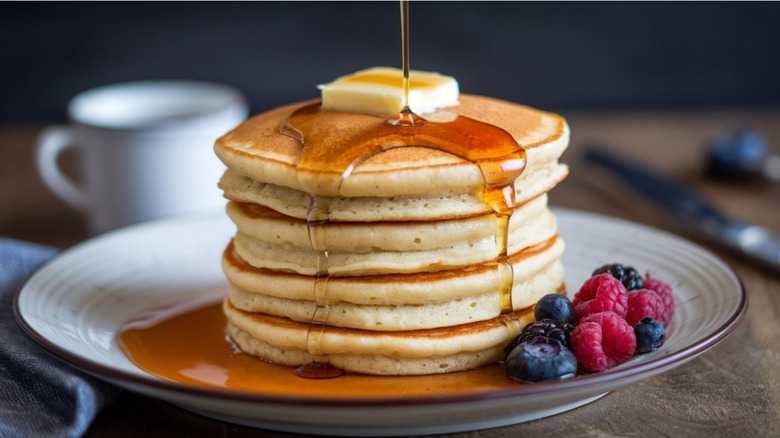 Syrup pouring over stack of pancakes