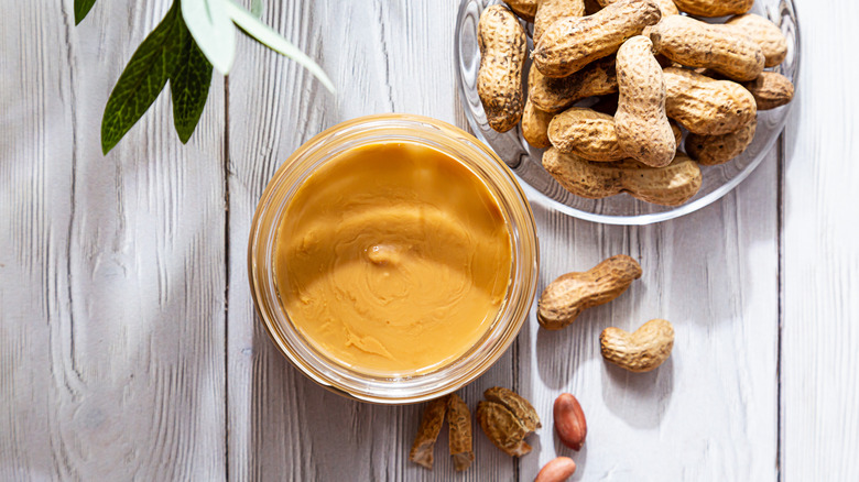 Peanut butter next to raw peanuts