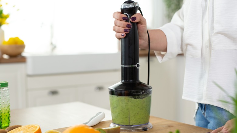 Woman blending green dressing