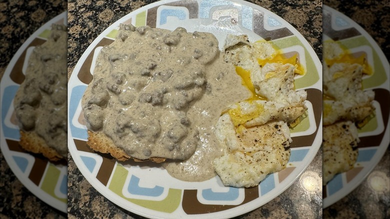 Hamburger gravy on toast with a side of eggs on a plate