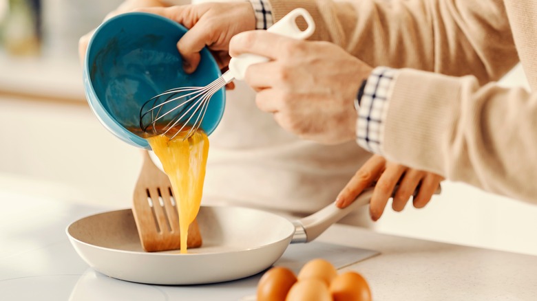 Pouring egg mixture into frying pan