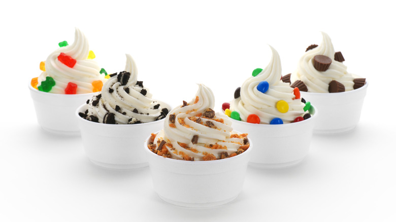 Cups of frozen yogurt with different toppings