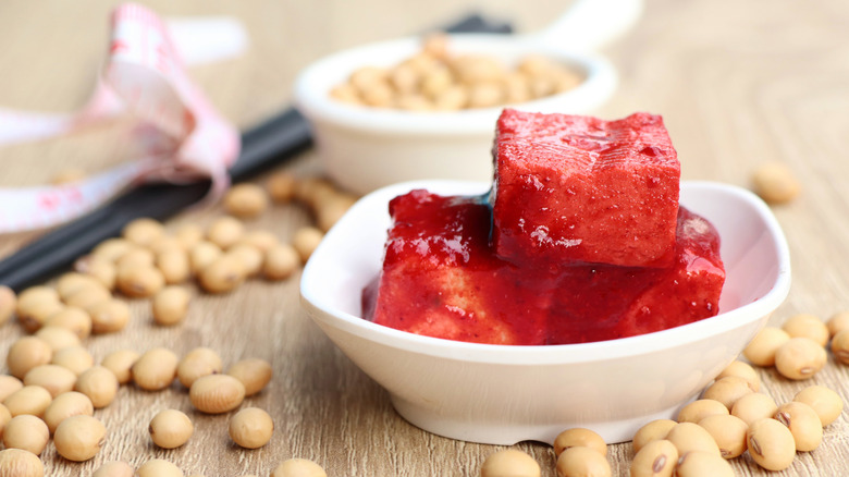 three squares of red tofu in a bowl