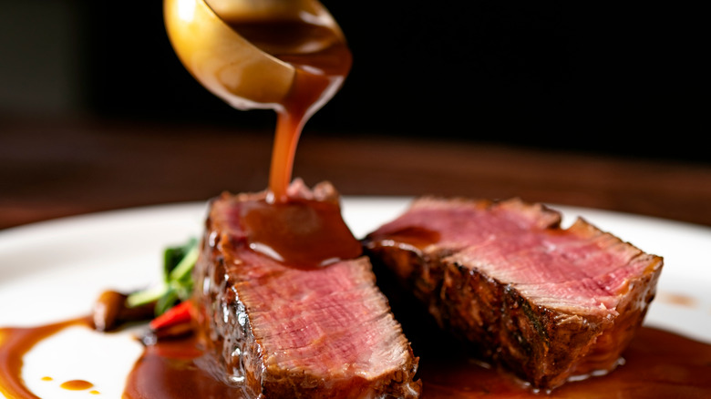 demi-glace pouring onto steak