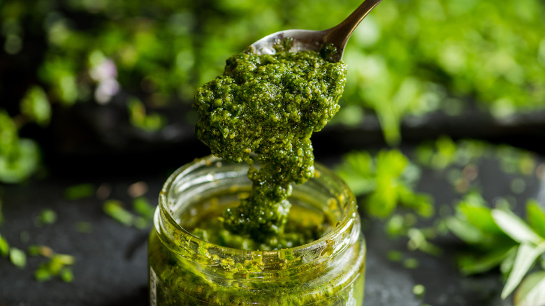 Spooning pesto from a jar