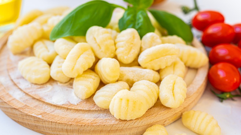 gnocchi on wooden board with tomatoes