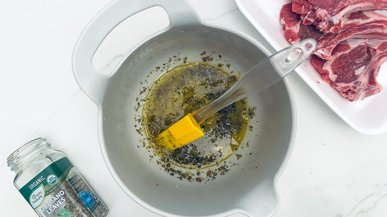 rubber spatula stirring oregano into meat marinade