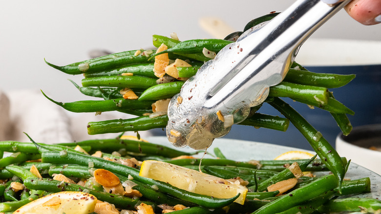 green beans held in tongs