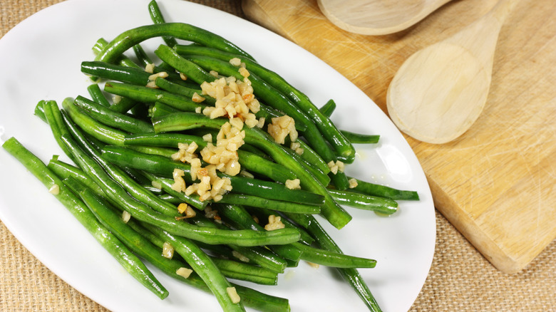 Sautéed green beans on an oval white plate