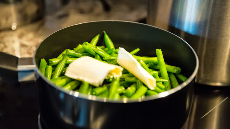 Pot of green beans topped with butter