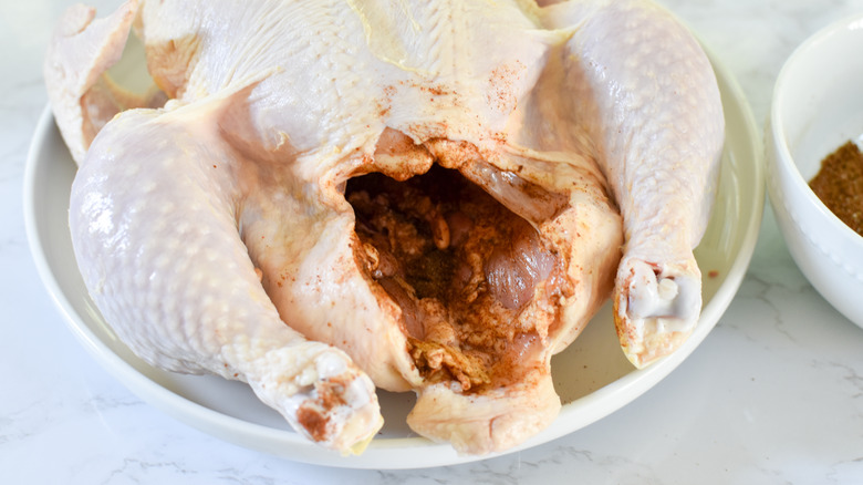 raw whole chicken on plate 