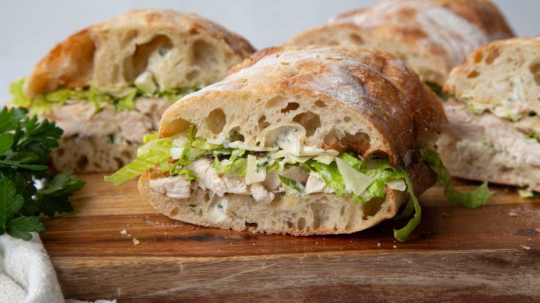 Chicken sandwiches with lettuce on a wooden board