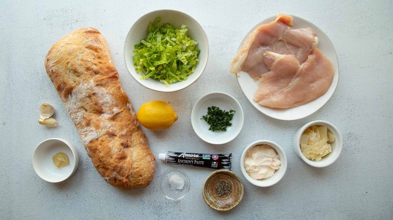 Raw chicken and bread with assorted produce and condiments