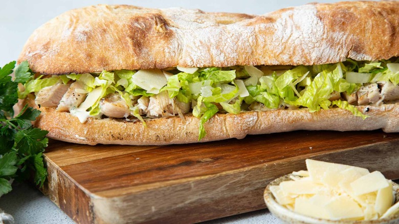 Chicken sandwich with lettuce on a wooden board