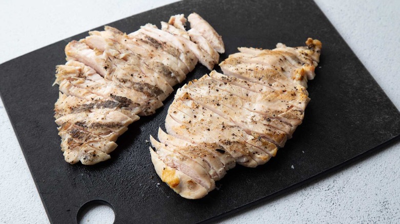 Chopped chicken on a black cutting board