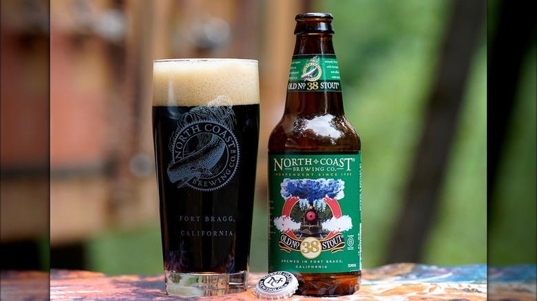 Glass and bottle of North Coast Brewing Company Old No. 38 Stout on a colorful cloth and background