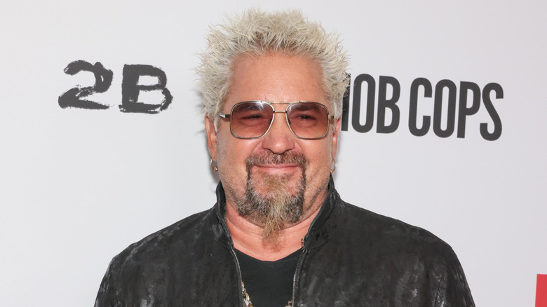 Guy Fieri smiling in glasses