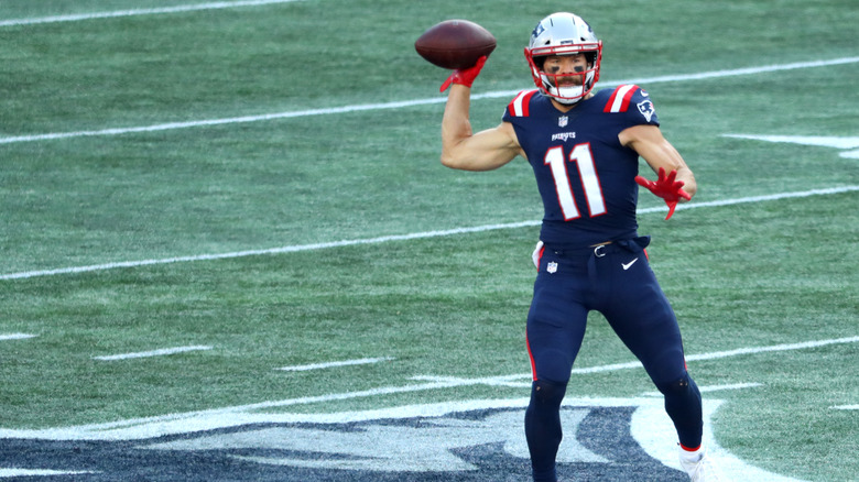 Julian Edelman wearing red gloves and throwing football