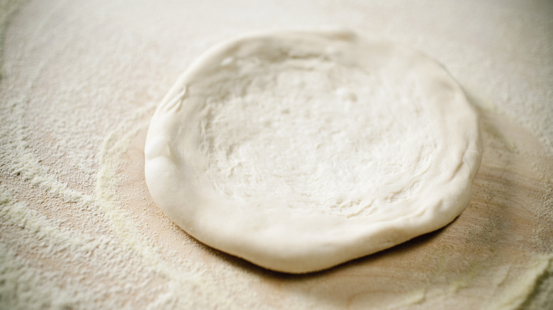 Pizza dough rolled out on flower