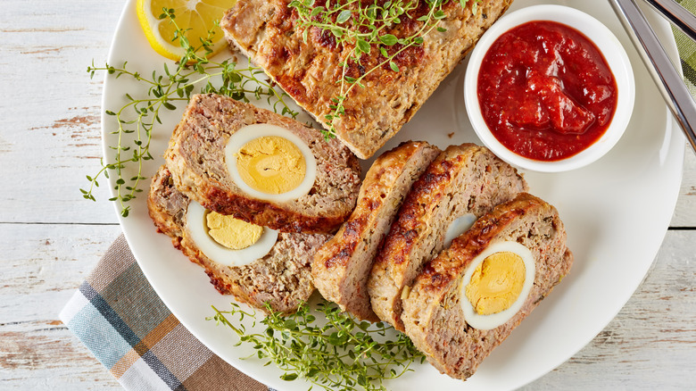 Egg-stuffed meatloaf sliced on a plate