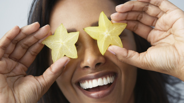 women smiling with sliced star fruit