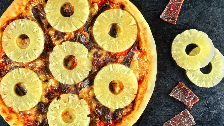 Pizza topped with ham bits and pineapple rings