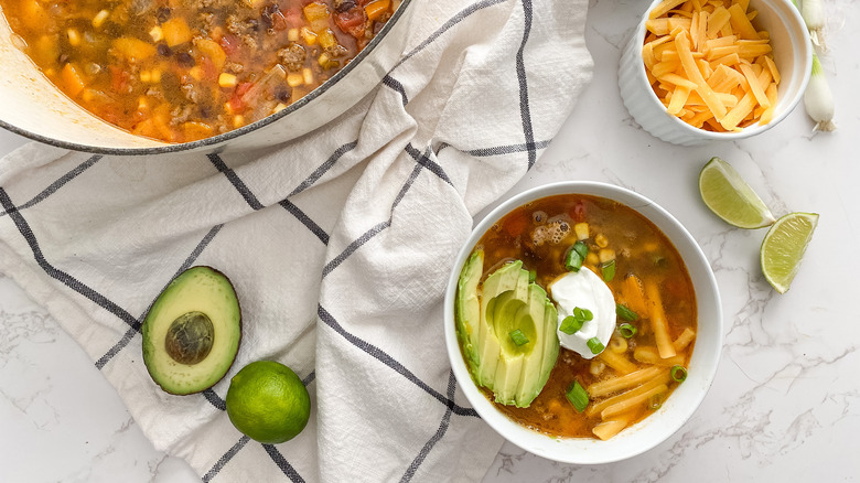 taco soup topped with avocado sour cream