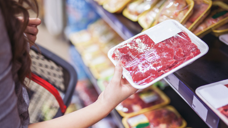 Holding wrapped raw meat in the grocery store
