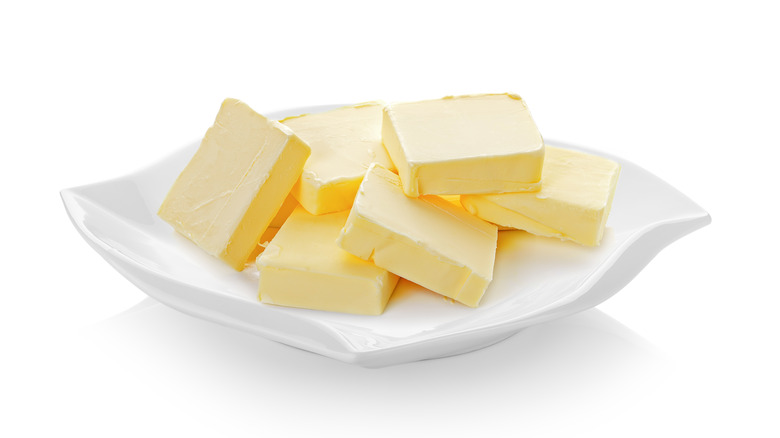 Pats of butter on a white dish