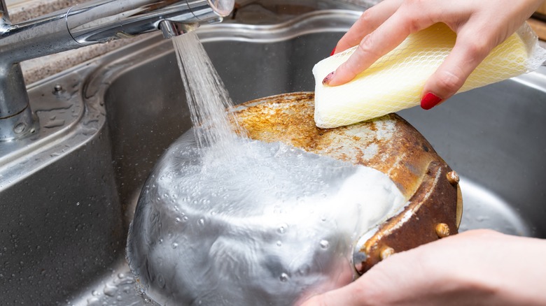 Woman washing aluminum plan