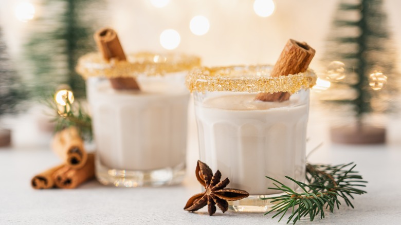 Eggnog in sugar rimmed glasses with cinnamon stick
