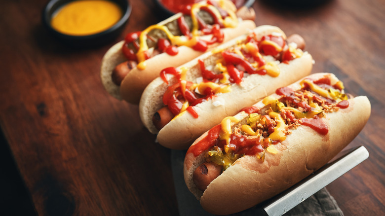 Three hot dogs on table