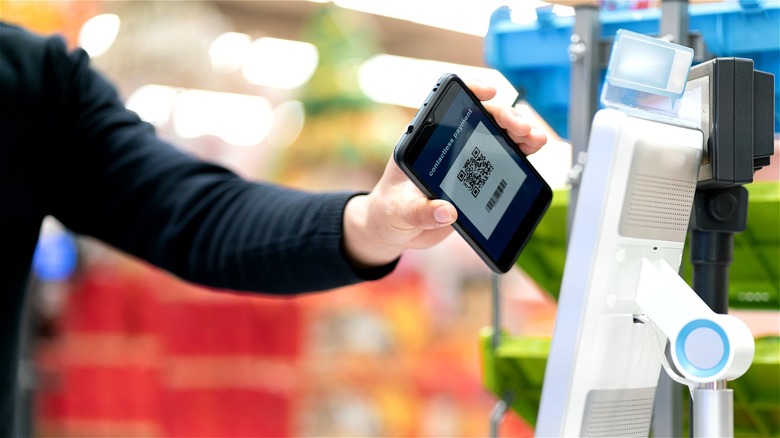 Hand scanning QR code on phone