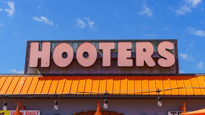 An orange Hooters sign above an orange awning