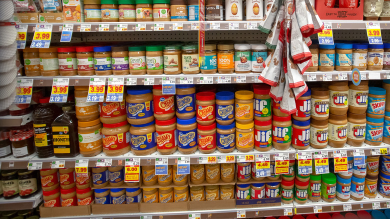 A variety of Kroger brand peanut butter for sale on the shelf of the grocery store