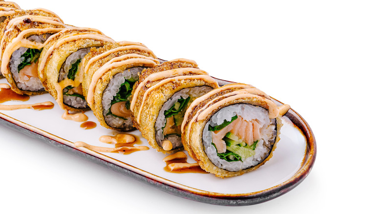 A crunchy fried sushi roll with salmon and a spicy mayo sauce drizzled on top