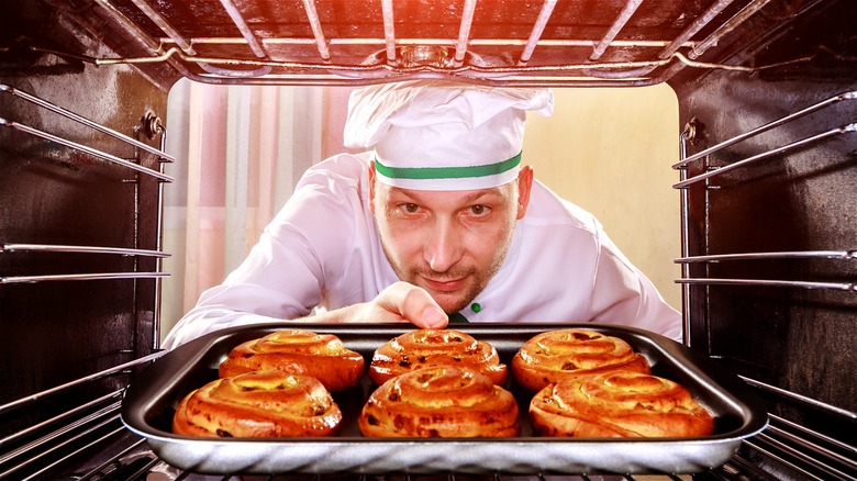 chef pulling rolls from oven