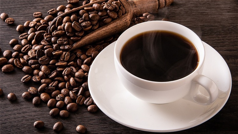 Steaming coffee mug and beans