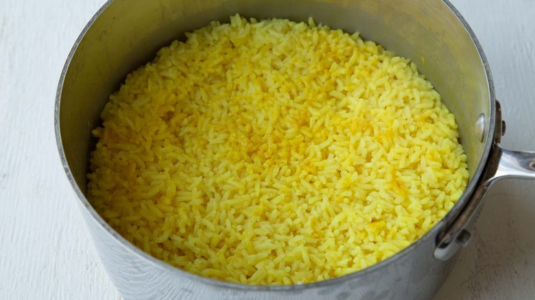 turmeric rice cooking in saucepan