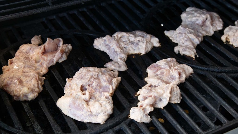 chicken thighs cooking on grill