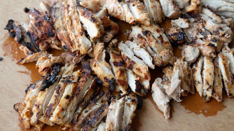 grilled chicken sliced on cutting board